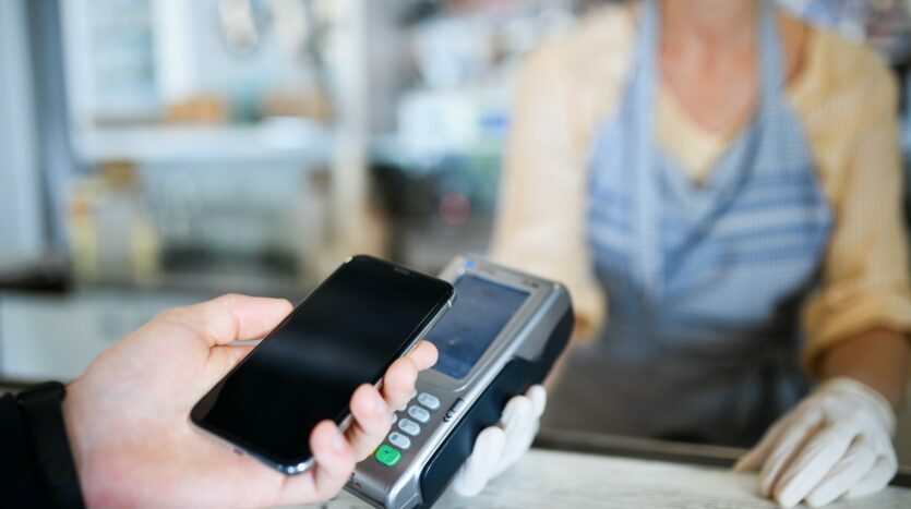 Contactless payment with smartphone, coffee shop open after lockdown